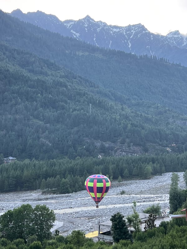 Hot air balloon ascends over Himalayan valley in Vashisht