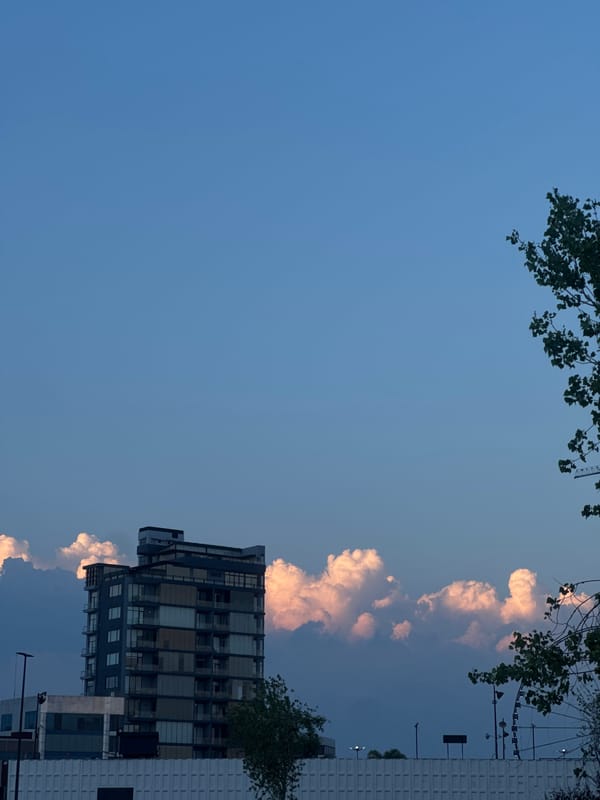 Pink clouds shroud buildings in evening Puebla cityscape