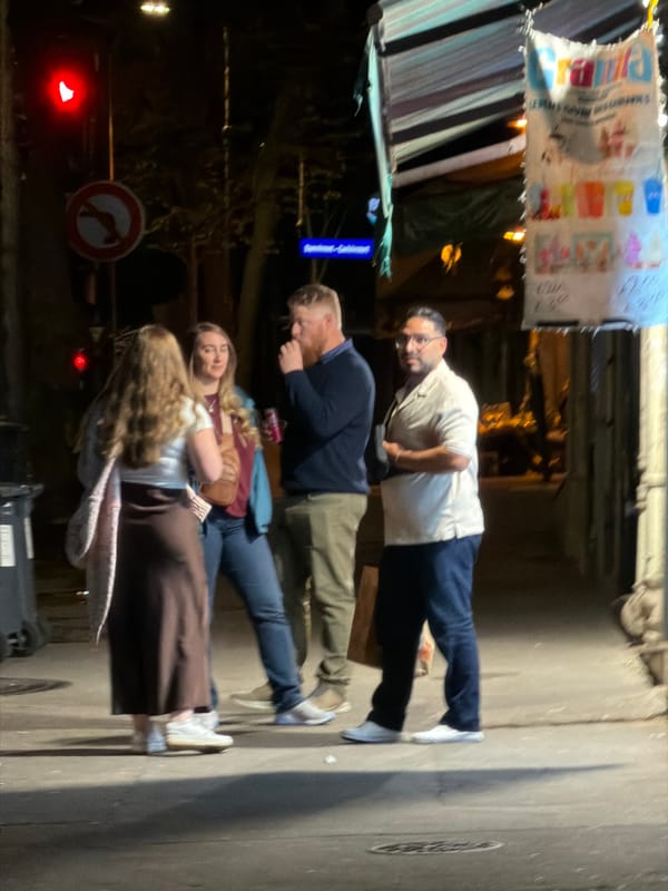 Evening gathering captured near illuminated Paris storefront
