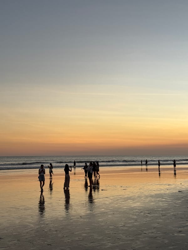 Kuta Beach fills up at golden hour on a June evening