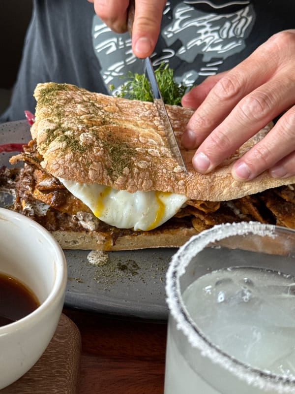 Person cuts sandwich during meal in San Andrés Cholula