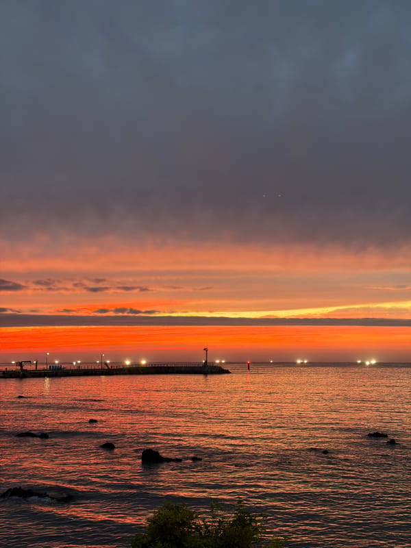 Jeju City coastline at golden hour, dusk settling in