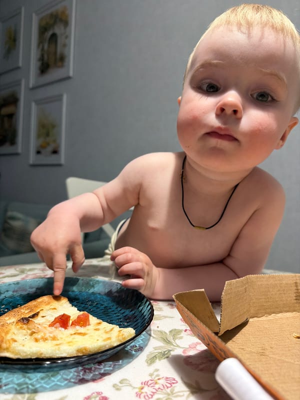 Child enjoys pizza dinner with dog in Votkinsk home