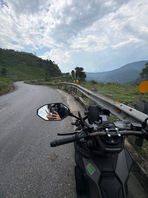 Motorcyclist rides winding mountain road near Huế, Vietnam