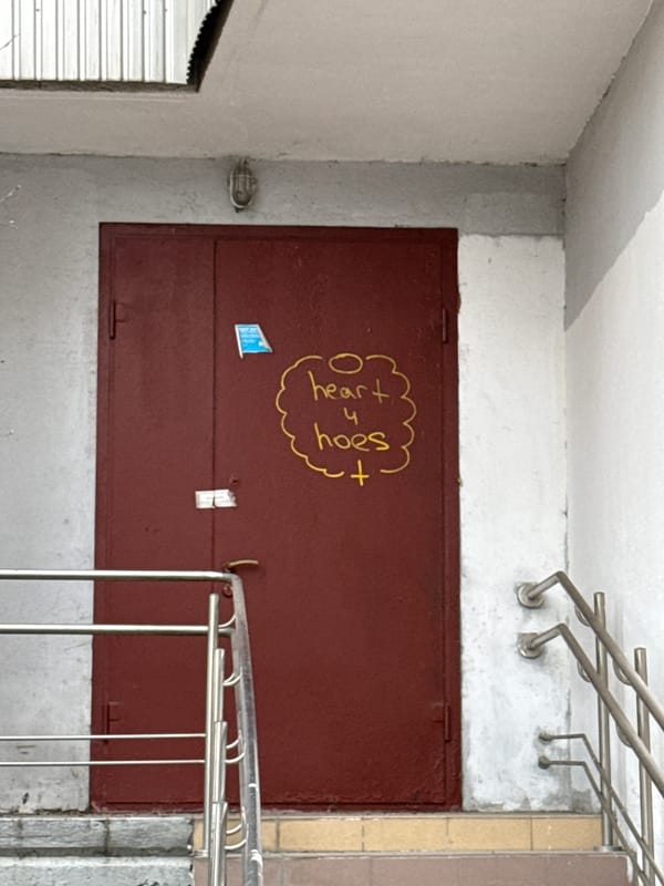 Moscow stairwell with graffitied maroon door documented by witness