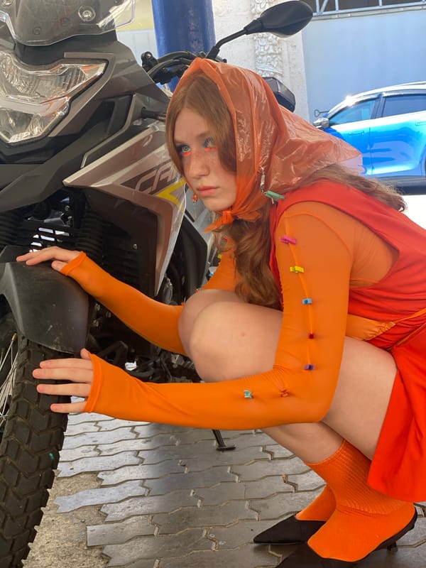 Bold orange outfit shoot near a yellow van in Sochi