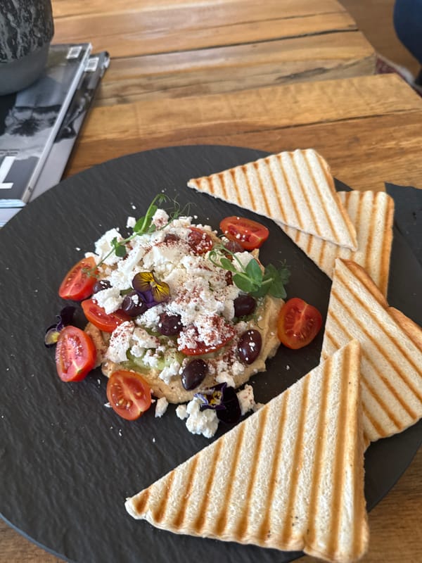 Mediterranean dish with hummus, feta, tomatoes photographed on slate