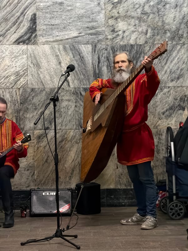 Traditional musicians busk in Moscow subway station wearing red tunics