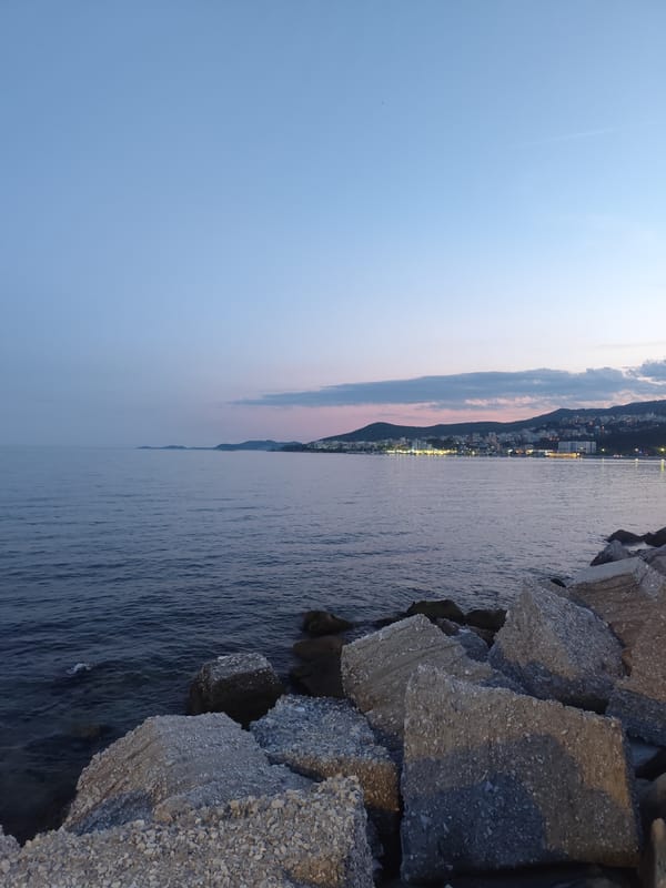 Concrete breakwater meets calm sea at dusk in Kavala