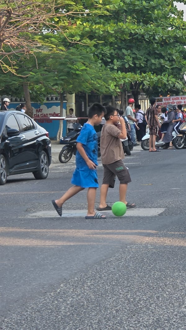 School children play with ball on Vietnam street