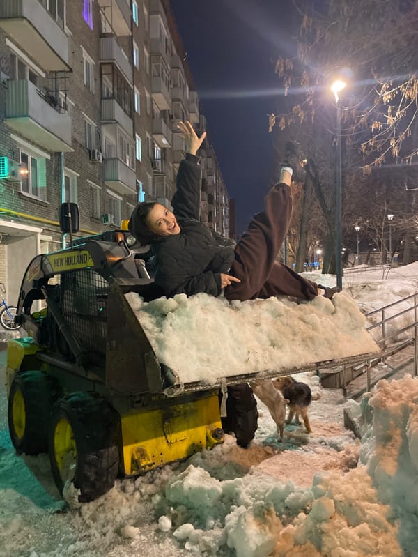 Woman poses on snow-filled loader in Moscow winter scene