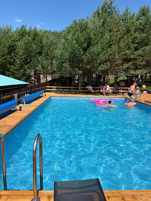 Poolside summer day in Elekmonar, surrounded by pine forest