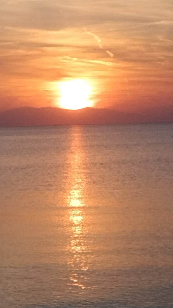 Sunset documented by beachgoers in Perea, Greece June 6