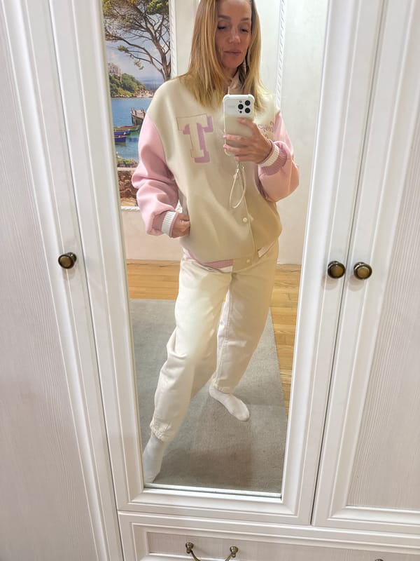Woman takes mirror selfie in varsity jacket, Vsevolozhsk