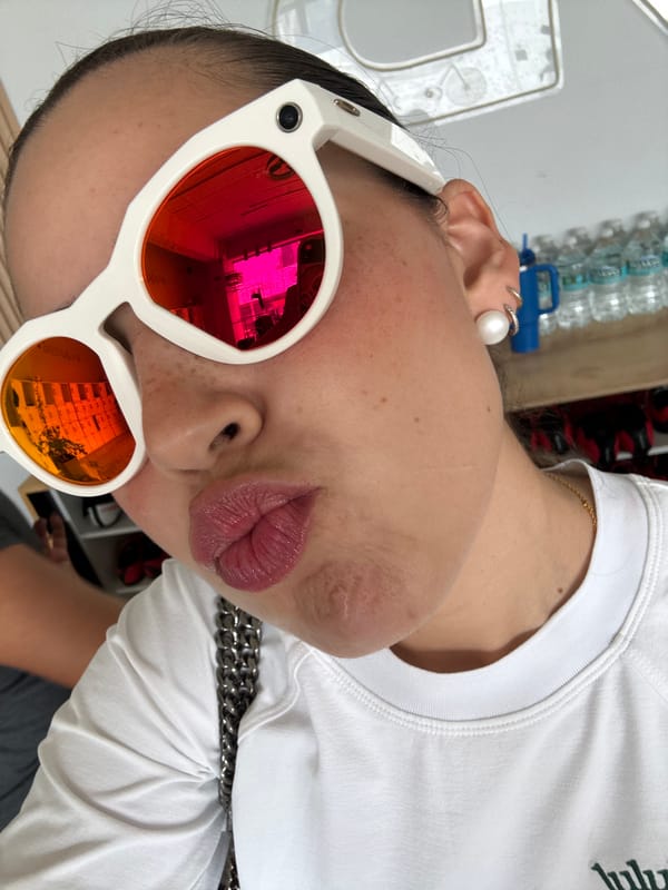 Woman takes selfie in Puebla shop wearing colorful sunglasses