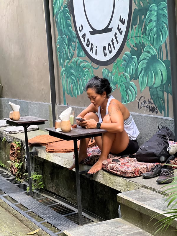 Woman enjoys beverage at outdoor cafe in Ubud