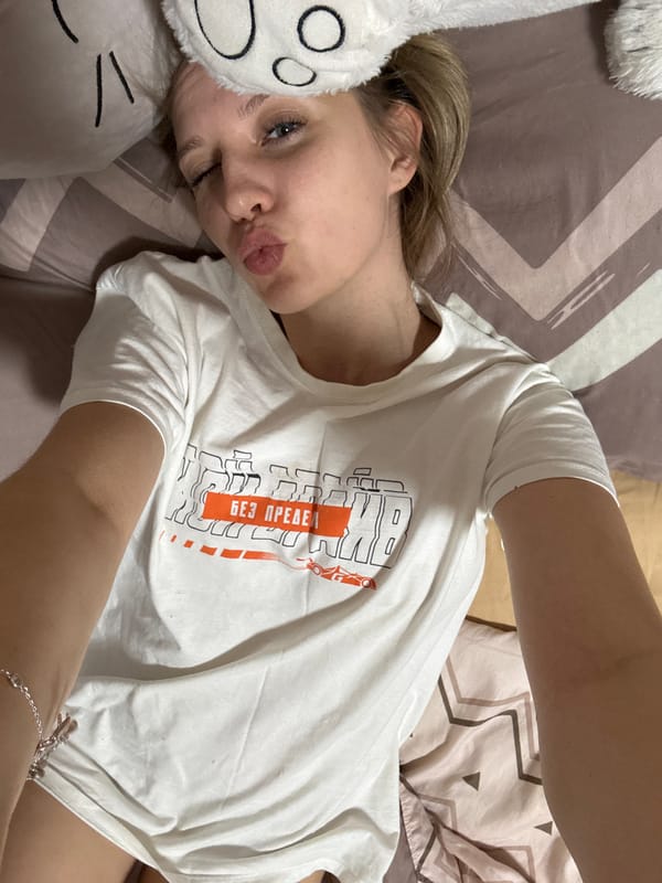 Woman takes selfies while petting rabbit indoors