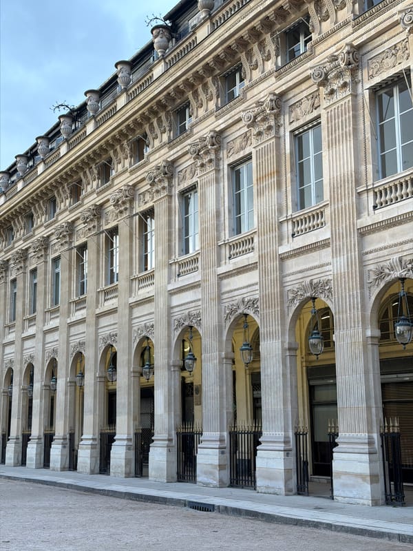 Woman checks phone in Palais Royal Garden, Paris
