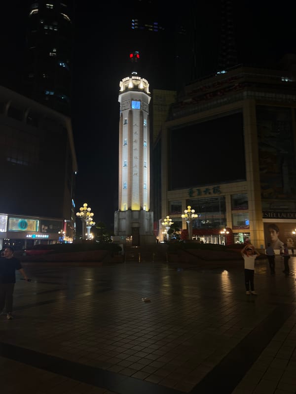 Night out in Chongqing's Yuzhong shopping district around a clock tower