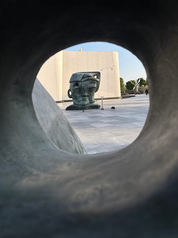 Bronze head sculpture observed through circular frame in Mexico