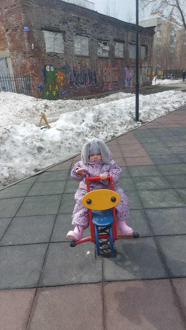 Child plays on snowy playground in Novosibirsk morning