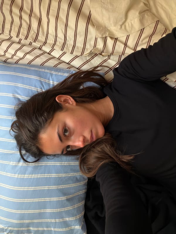 Woman resting on bed observed in Paris indoor location