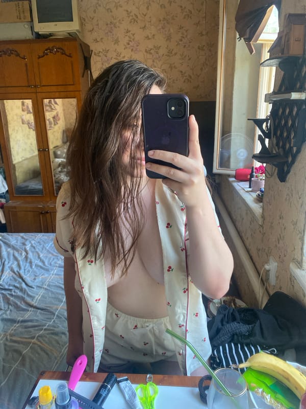 Mirror selfies in a floral-wallpapered bedroom, two looks