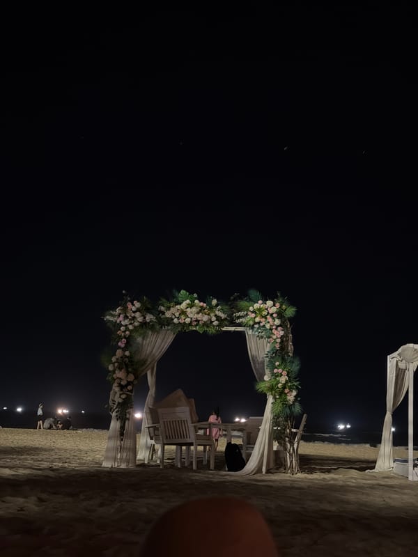 Nighttime beach celebration with floral archway in Đà Nẵng