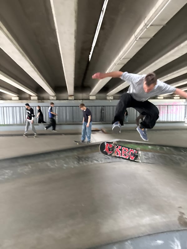 Skaters and a cyclist session an underpass skatepark in St. Petersburg
