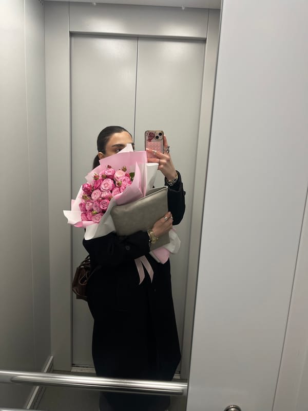 Person takes elevator selfie with pink rose bouquet in Yerevan
