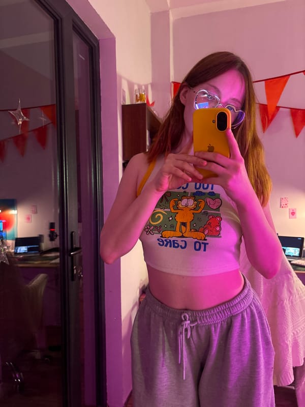 Woman takes selfie in heart-shaped glasses, cartoon top in Yerevan