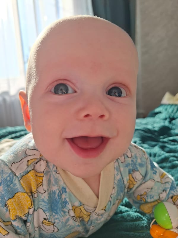 Baby in bear-patterned onesie observed at unknown location