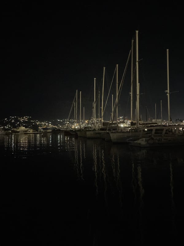Purple-lit superyacht docked at Bar Marina after dark