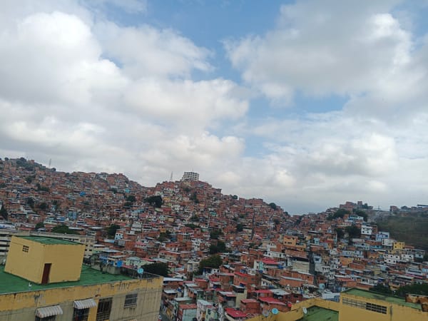Hillside favela documented in Caracas under partly cloudy skies