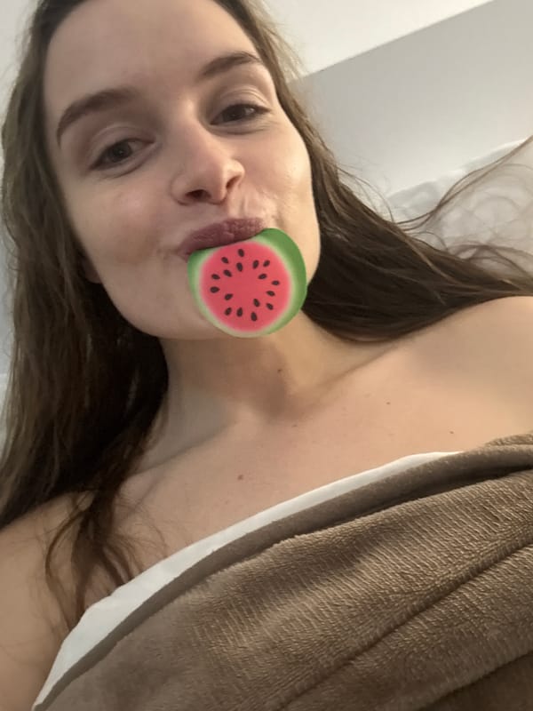 Woman poses playfully with watermelon stickers in Budva bedroom