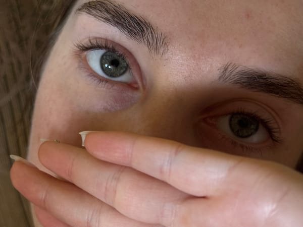 Close-up portrait captured with hand partially covering face