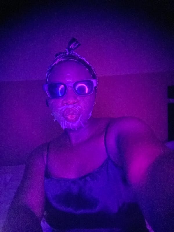 Person spotted in colorful lighting wearing mask, sunglasses in Nigeria