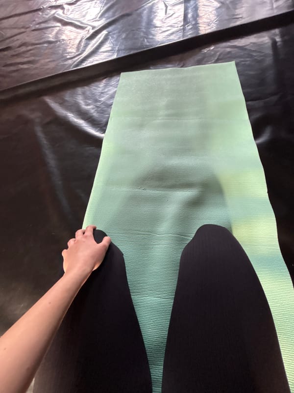 Person sets up yoga mat at indoor facility
