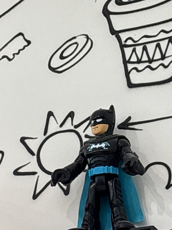 Artistic expressions and Batman figure documented at indoor location