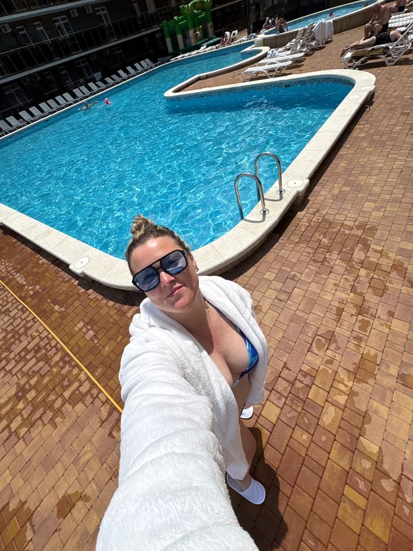 Woman takes poolside selfie at resort complex