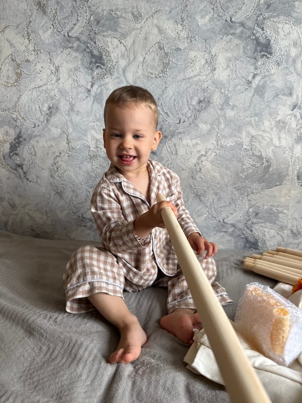 Toddler plays with tent poles in morning pajamas