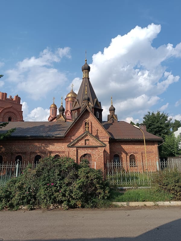 Red-domed Orthodox church in Il'inskiy seen from rail and ground