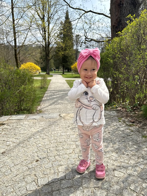 Child enjoys spring morning in Wisła park amid blooming shrubs