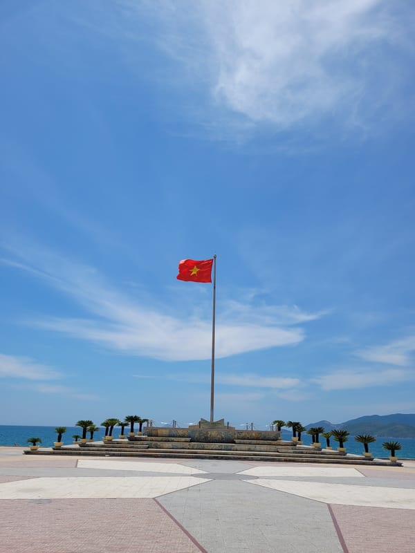Coastal scenes with Vietnamese flag, buildings, decorated rickshaw captured