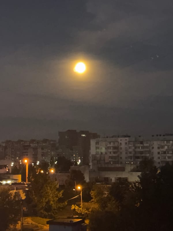 Moonlit sky over Kyiv's skyline at night