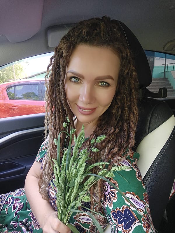Woman holds grass while sitting in parked car