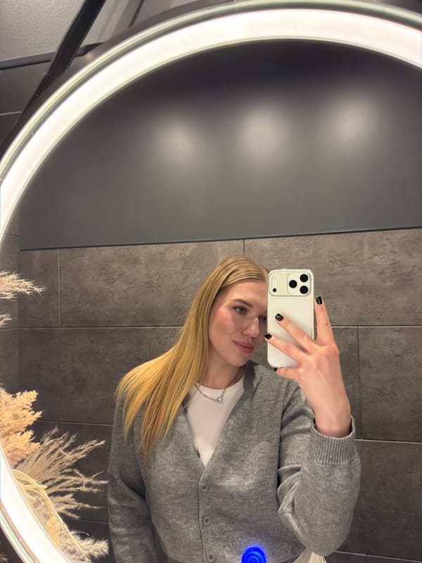 Woman takes mirror selfie with smartphone in Riga
