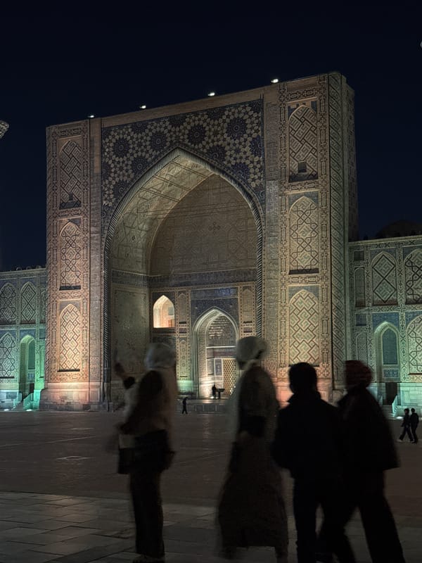 Historic Samarkand landmarks illuminated during evening tourist activity