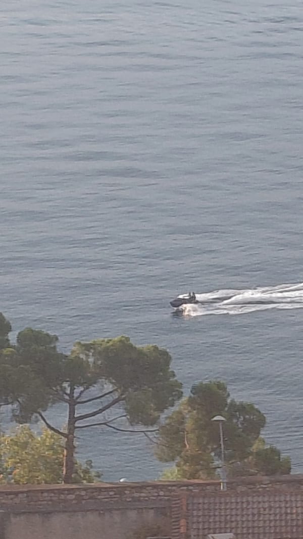Jet ski on calm water, cat candles melting nearby in Aegio
