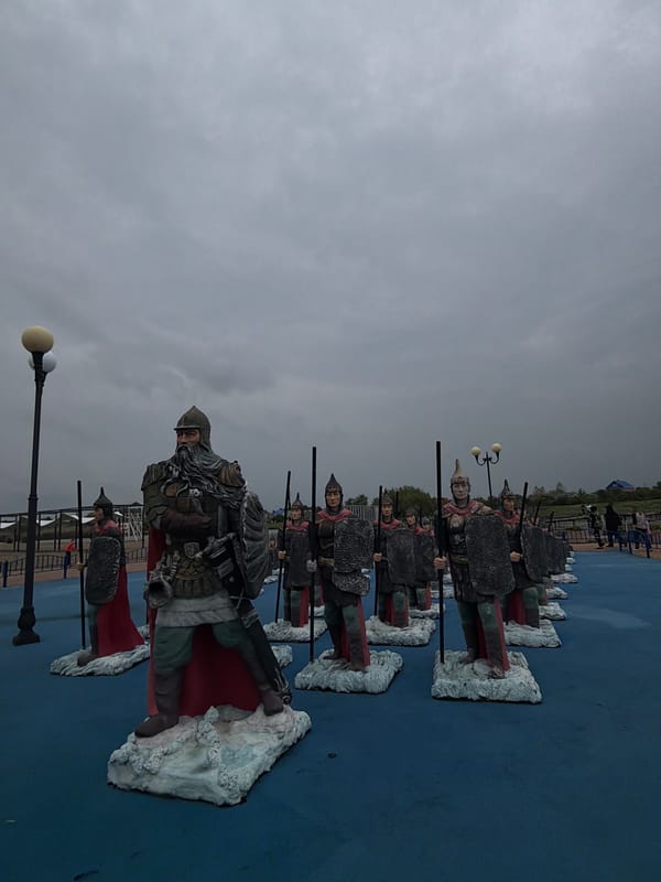 Warrior statues and peacock display captured at unknown location